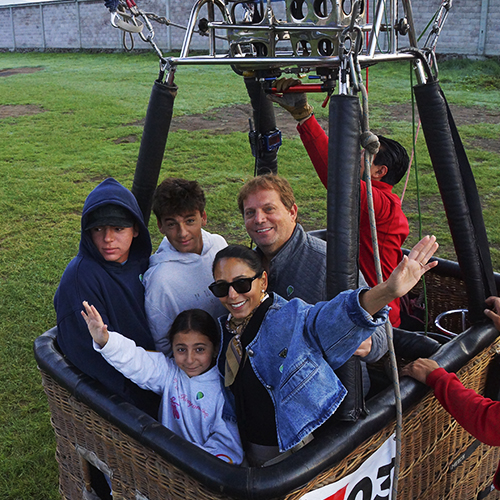 Familia saludando desde la canastilla del globo