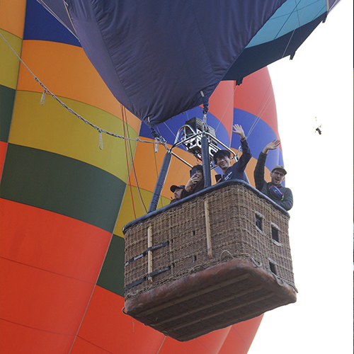 Viajeros saludando durante su vuelo en globo