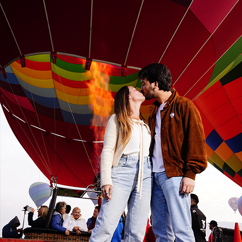 Pareja celebrando frente a un globo aerostático
